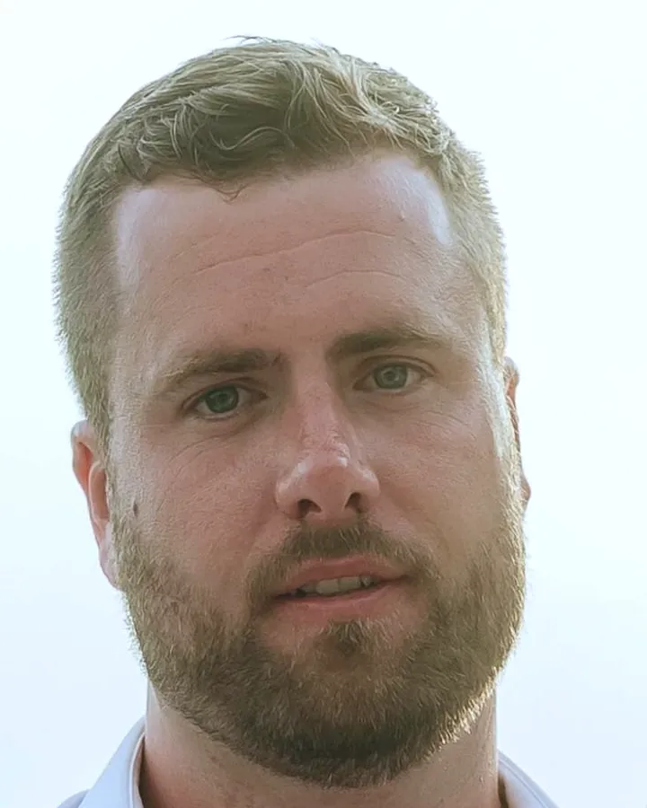 Portrait of John, a bearded man with short hair, looking at the camera
